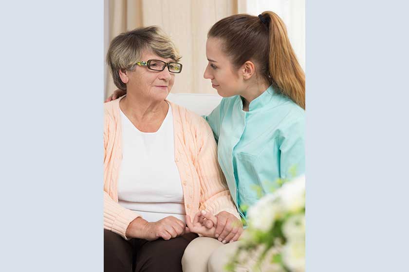 Elderly female sitting beside nurse