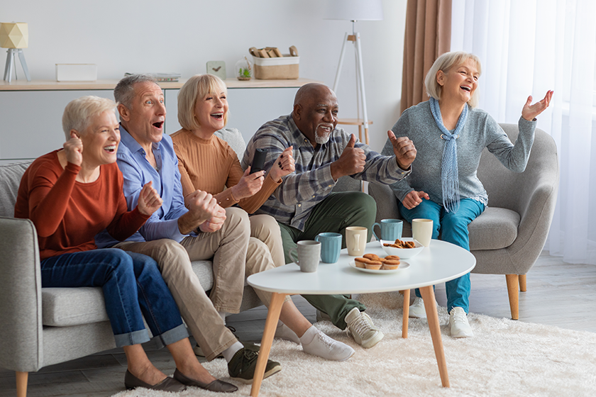 Emotional senior people watching television in the living room 