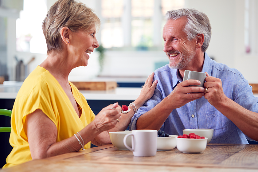 Retired Couple Sitting Around Table At Home Having Healthy Breakfast Together 